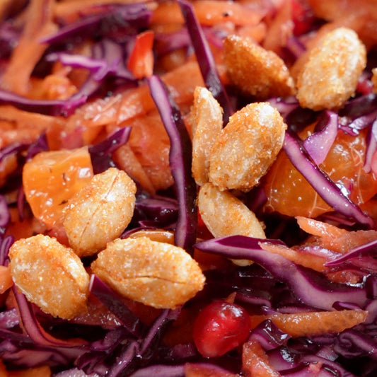Olives Et Al Hot Honey Mixed Nuts - Salad with purple cabbage, oranges, and croutons on a bed of red cabbage