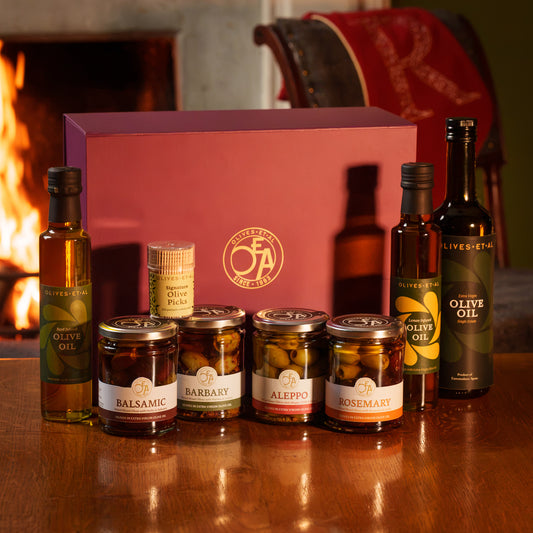 Olives Et Al Olives & Olive Oil Hamper, beautifully presented in a purple gift box, featuring three bottles of premium olive oil, four jars of delicious marinated olives and signature olive picks. The collection includes House Extra Virgin Olive Oil, fragrant Basil Olive Oil and zesty Lemon Olive Oil, alongside Balsamic, Rosemary, Aleppo and Barbary Olives. Perfect for Christmas gifting,