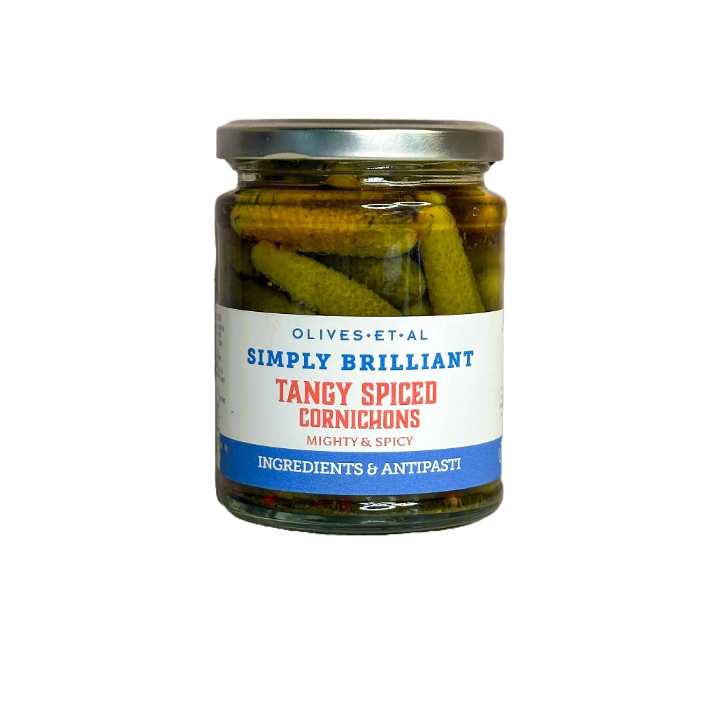 Jar of tangy spiced cornichons with a label on a white background