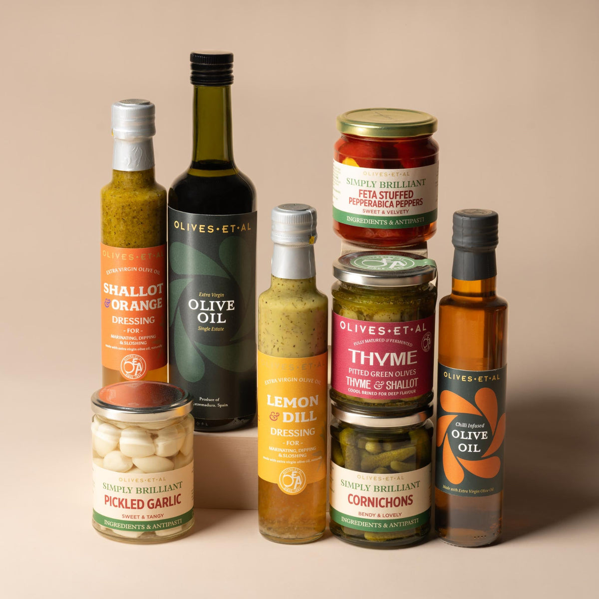 Olives Et Al BBQ Salads & Sides Bundle featuring eight bottles and jars of Mediterranean-inspired accompaniments for salads, grilling and sharing. The collection includes Aleppo Chilli Olive Oil, House Extra Virgin Olive Oil, Rich Shallot and Orange Dressing, and Lemon and Dill Dressing made with Extra Virgin Olive Oil. Savoury jars include Thyme and Shallot Pitted Green Olives, crisp Pickled Cornichons, Sweet Pickled Garlic Cloves and Feta Stuffed Pepperabica Peppers. Together, the selection combines fruit