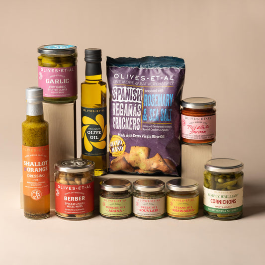 Olives Et Al Barbecue Bundle featuring eleven jars, bottles, bags and spice blends for grilling, sharing and outdoor dining. The selection includes Adana Turkish Kebab, Shawarma Levantine and Souvlaki Greek grilling spice blends, alongside Harissa North African chilli paste and zesty Lemon Olive Oil. Savoury accompaniments include Rich Shallot and Orange Dressing, Pickled Cornichons, Thyme and Shallot Pitted Green Olives and Garlic Stuffed Olives. The bundle also contains crunchy Berber Sweet Chilli Harissa