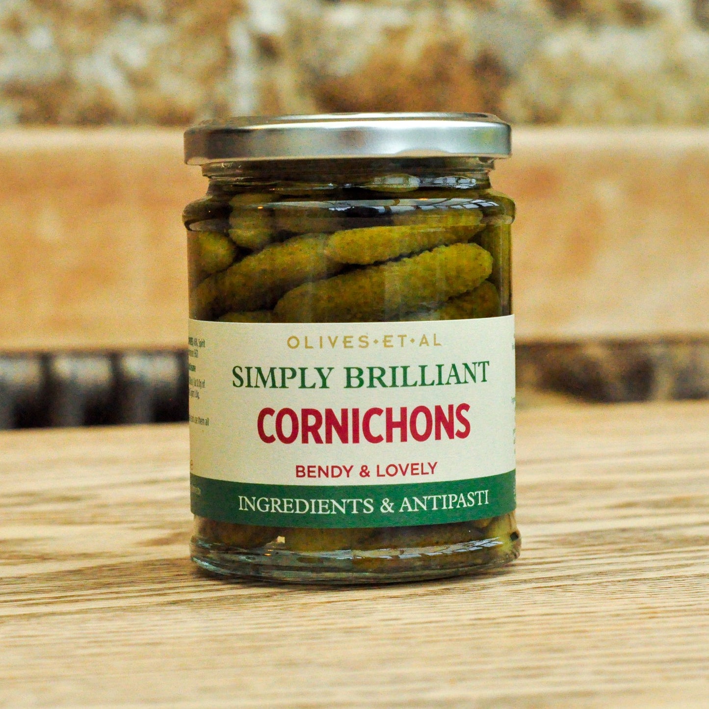 Jar of cornichons with a label on a wooden surface