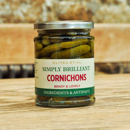 Jar of cornichons with a label on a wooden surface