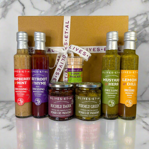 Collection of Olives Et Al food products including bottles and jars on a neutral background