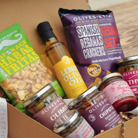 Assorted snacks and oils in a box with visible brand names.