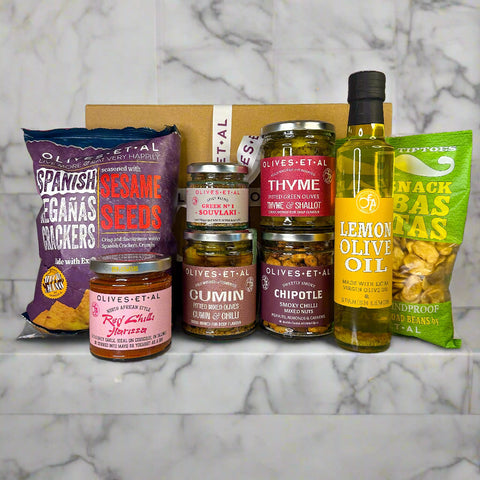 Assorted food products including jars, a bottle, and bags on a countertop with a neutral background.