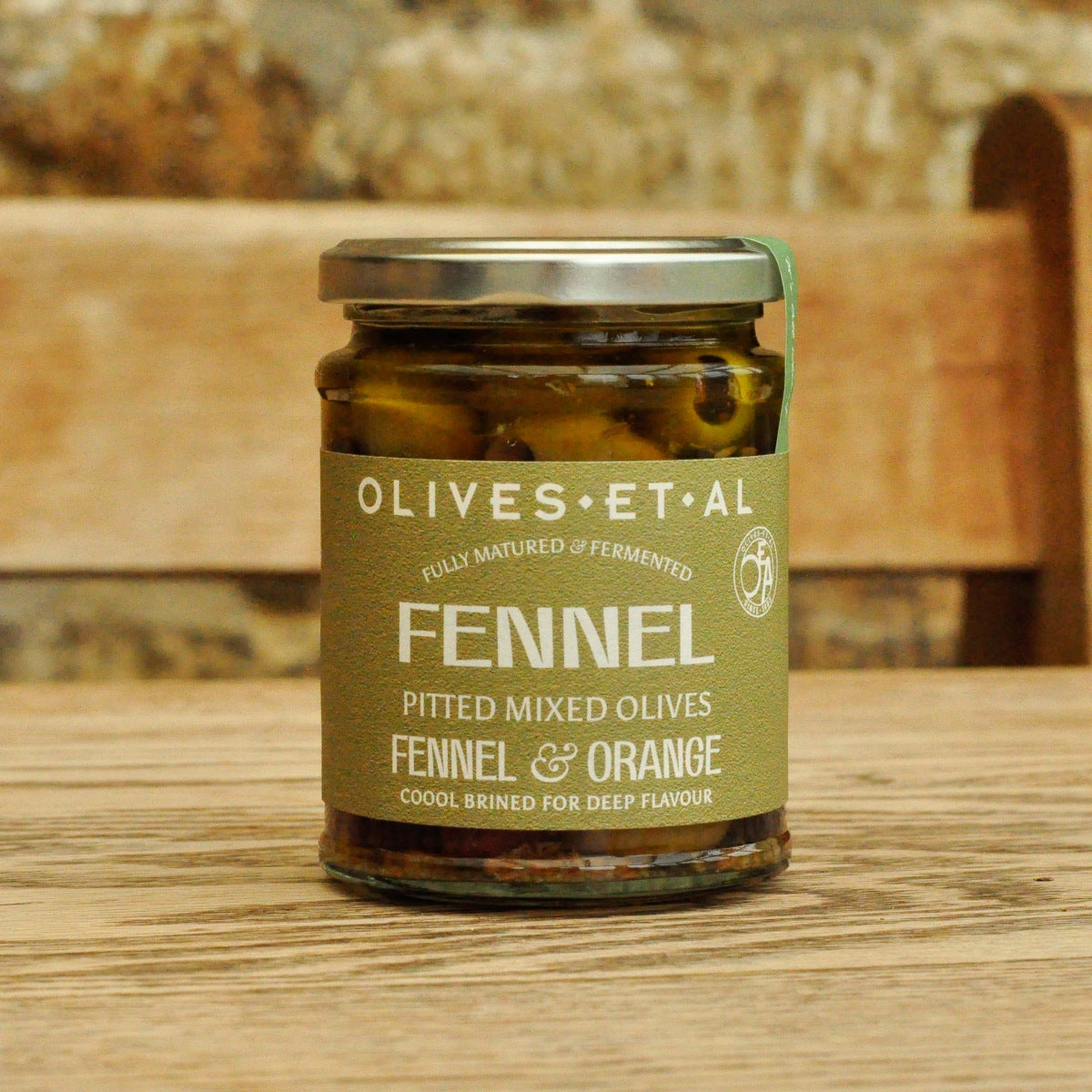 Close-up packshot of fennel orange olives jar label