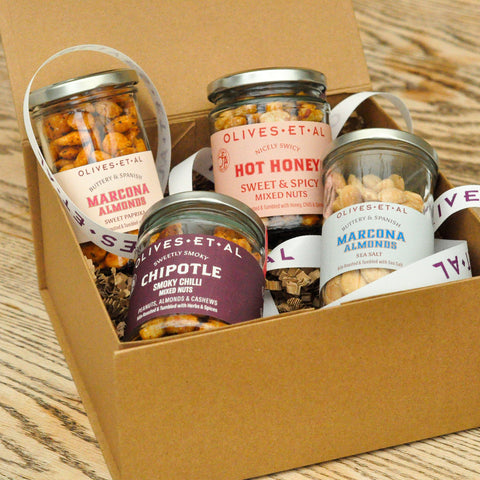 Box of Olives Et Al nut  jars on a wooden surface