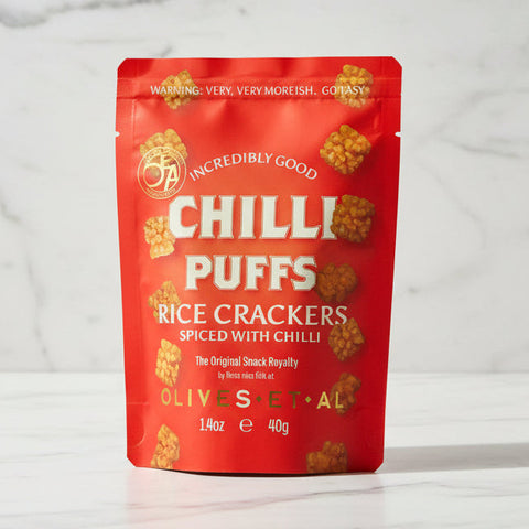 Red package of Chilli Puffs rice crackers on a marble background