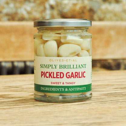 Jar of pickled garlic with a label on a wooden surface