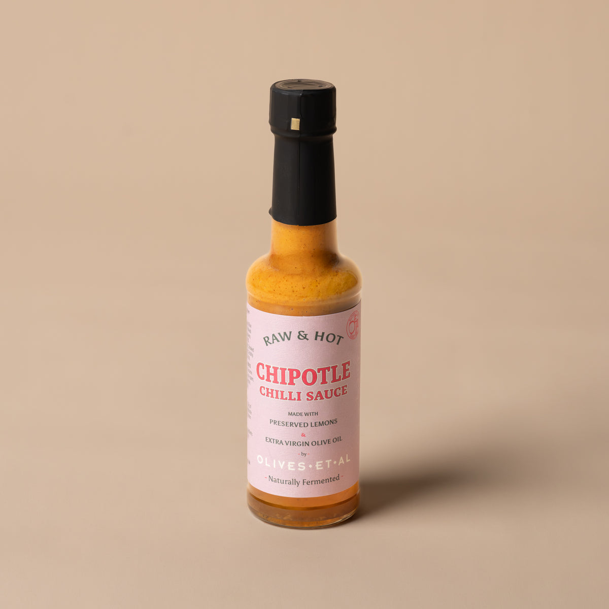 Bottle of Raw & Hot Chipotle Chilli Sauce on white marble
