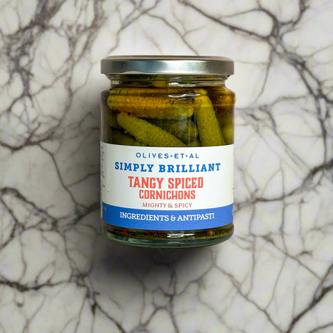 Jar of tangy spiced cornichons on a marble surface