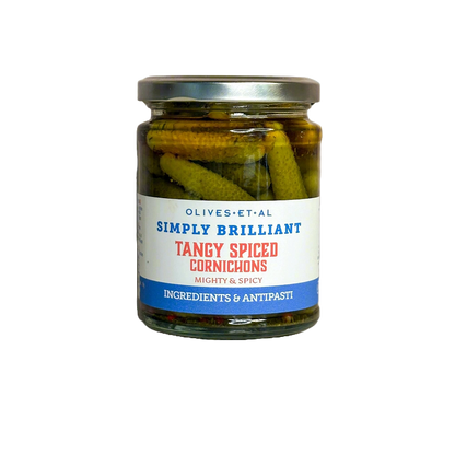 Jar of tangy spiced cornichons with a label on a white background