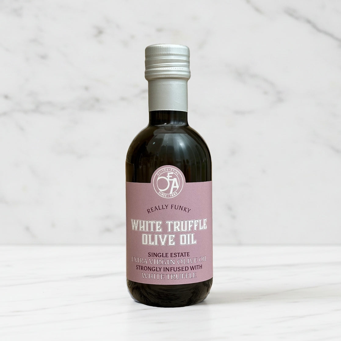 Bottle of white truffle olive oil with a pink label on a marble background