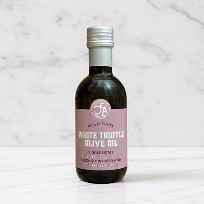 Bottle of white truffle olive oil with a pink label on a marble background