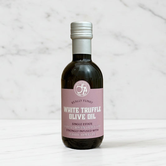 Bottle of white truffle olive oil with a pink label on a marble background