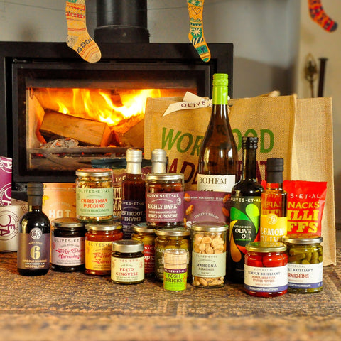 Assorted food products including jars and bottles on a table with a fireplace in the background.