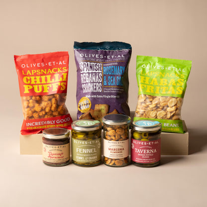 Olives Et Al While the BBQ Heats Up Bundle featuring eight savoury snacks and accompaniments for sharing before grilling. The selection includes Chipotle Smoky Chilli Nuts, Sweet Paprika Marcona Almonds and rich Tapenade Marocaine, alongside Taverna Mixed Pitted Olives in Extra Virgin Olive Oil and fragrant Fennel and Orange Pitted Mixed Olives. Crisp Rosemary and Sea Salt Regañas Crackers provide a crunchy pairing for the tapenade and olives.