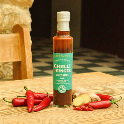 Bottle of Chilli Ginger dressing with ingredients on a wooden surface