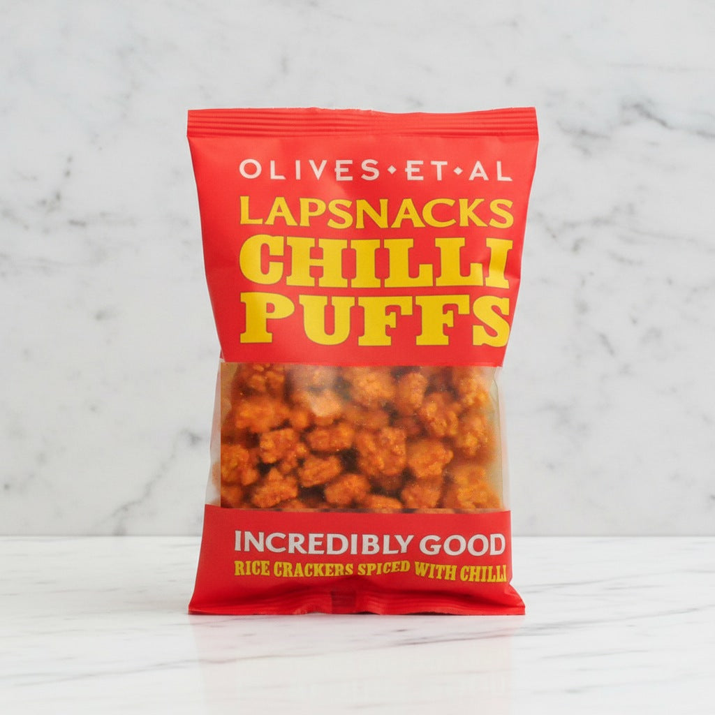 Bag of Olives Et Al Lapsnacks Chilli Puffs on a marble background