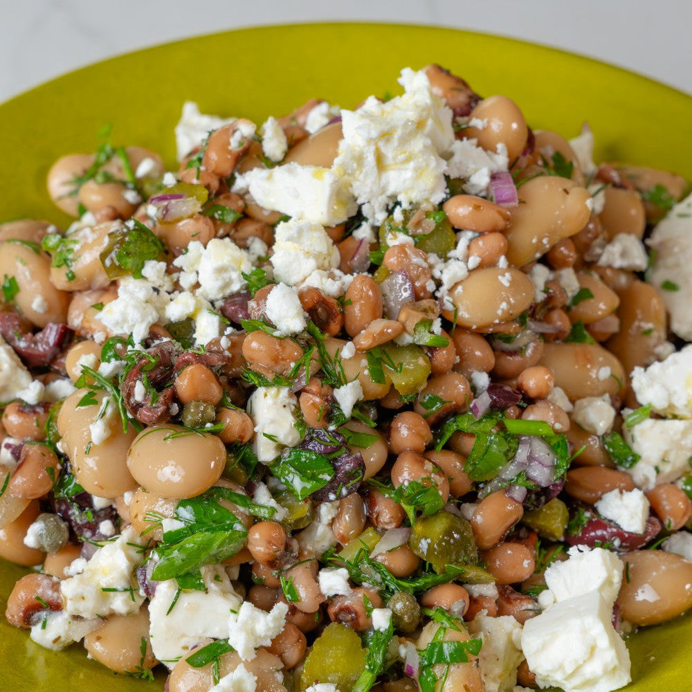 Bean salad with crumbled cheese on a green plate