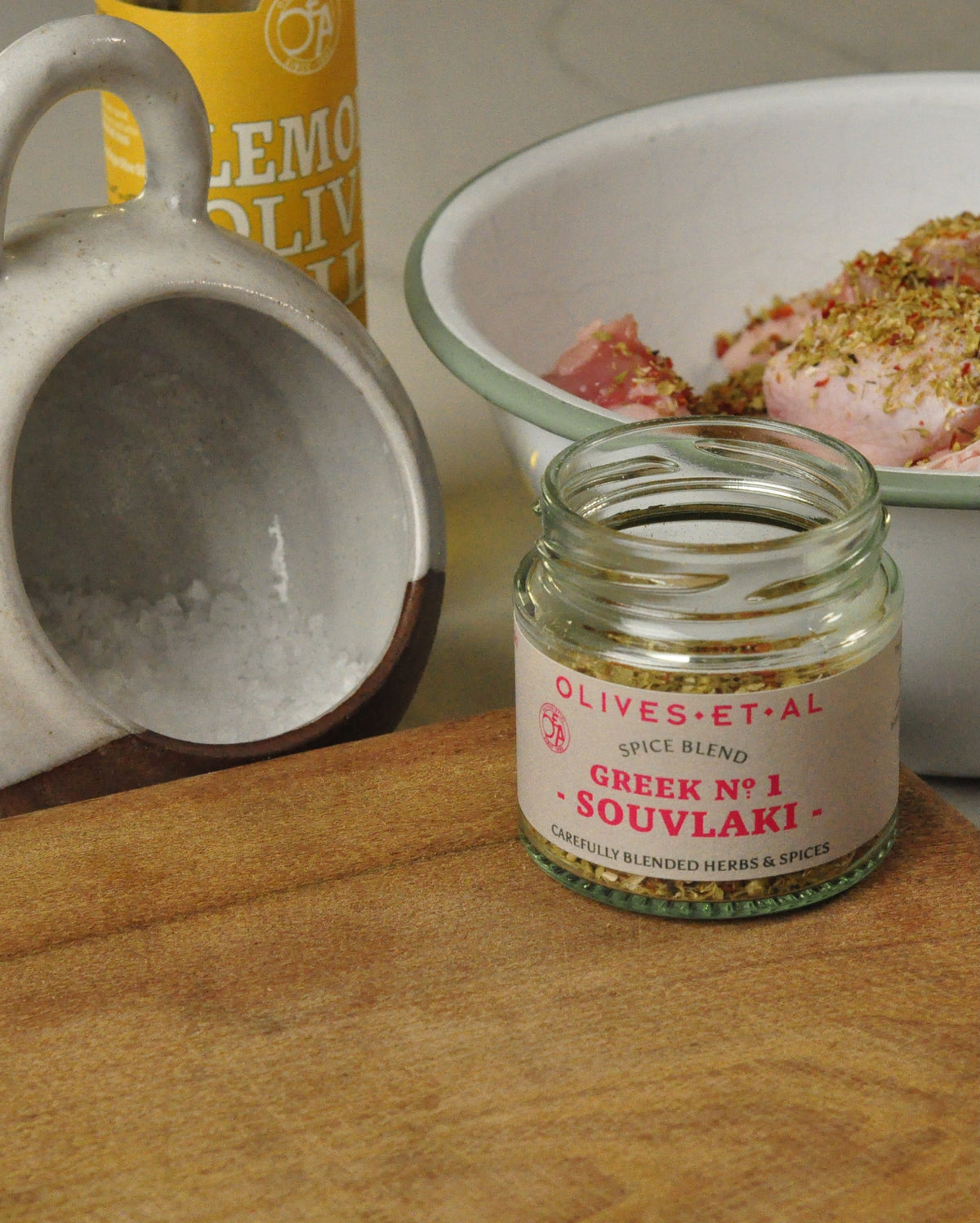 Souvlaki spice blend beside seasoned chicken, Lemon Olive Oil and sea salt