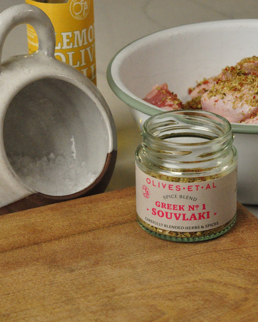 Souvlaki spice blend beside seasoned chicken, Lemon Olive Oil and sea salt