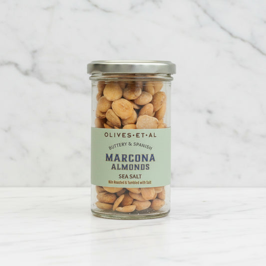 Olives Et Al Marcona Almonds on a white marble background