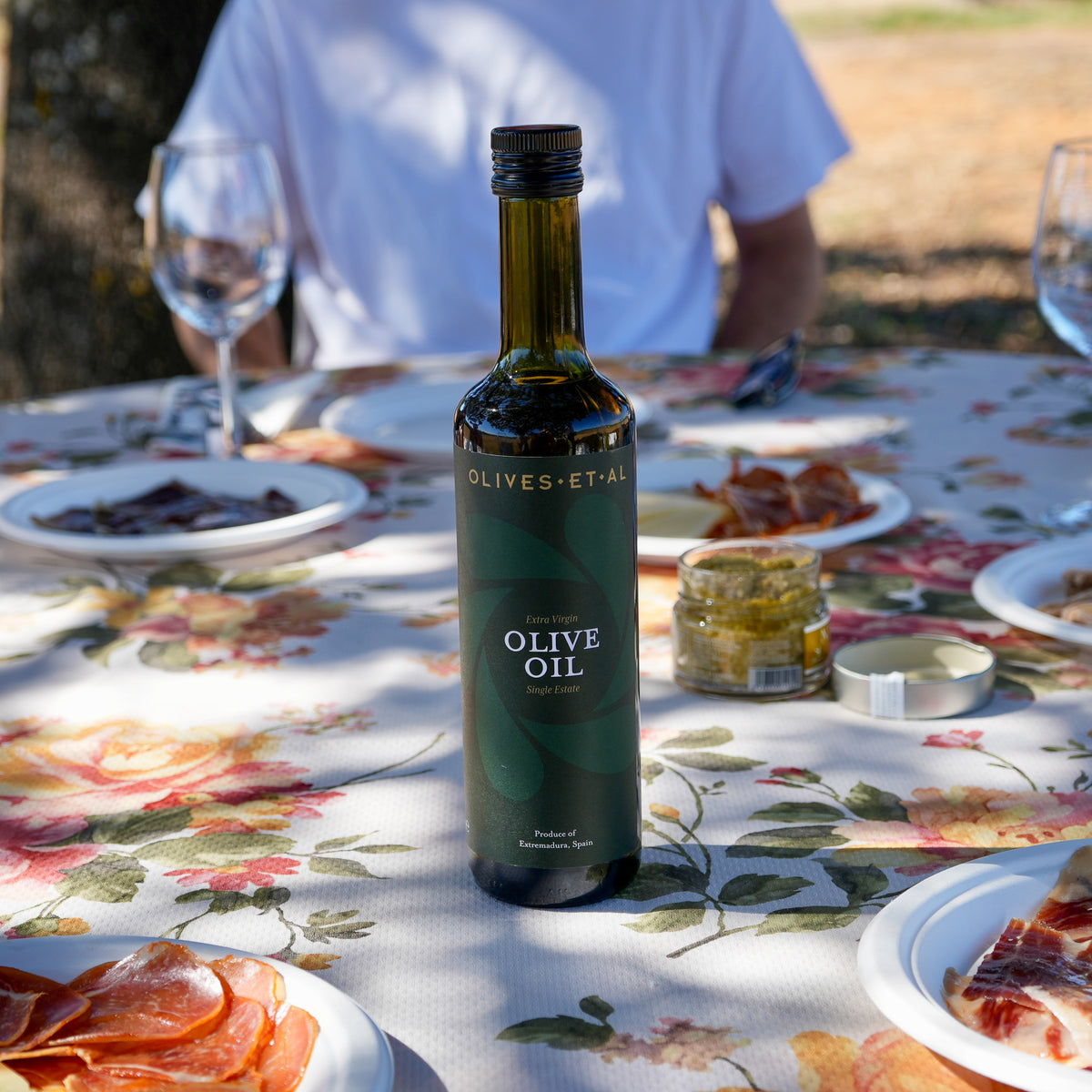 Olives Et Al House Extra Virgin Olive Oil 500ml bottle on an outdoor dining table
