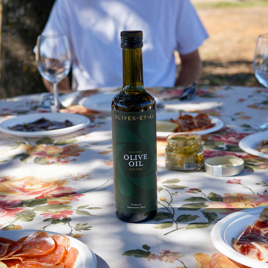 Olives Et Al House Extra Virgin Olive Oil 500ml bottle on an outdoor dining table