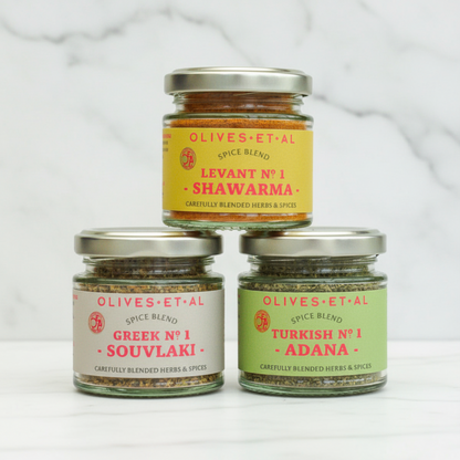 a trio of spice blends in jars of white marble background